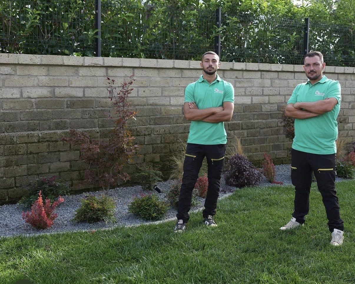 Gianluca e Federico di GF Garden in un giardino appena terminato, con aiuola di arbusti su ghiaia e prato nuovo